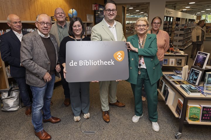 Gedeputeerde Marc van Caldenberg (midden) overhandigt symbolisch de eerste gratis bibliotheekpas aan medewerkers van de bibliotheek in Landgraaf