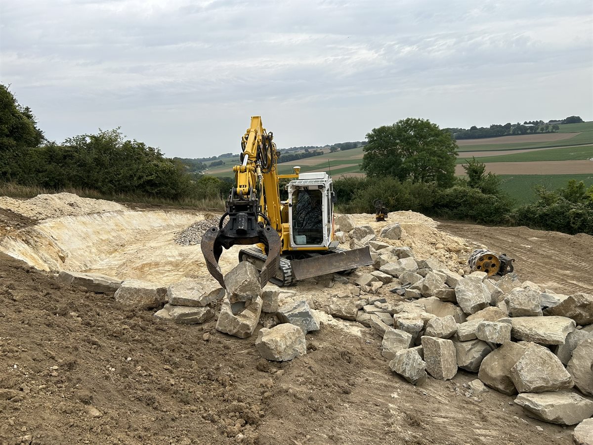 Plaatsen van een stapelmuur voor de poel