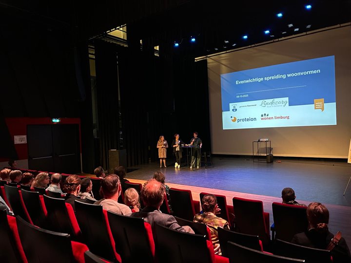 Sprekers op het podium tijdens de netwerkbijeenkomst