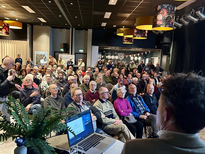 Volle zaal bezoekers kijkt naar de presentatie tijdens de inloopbijeenkomst