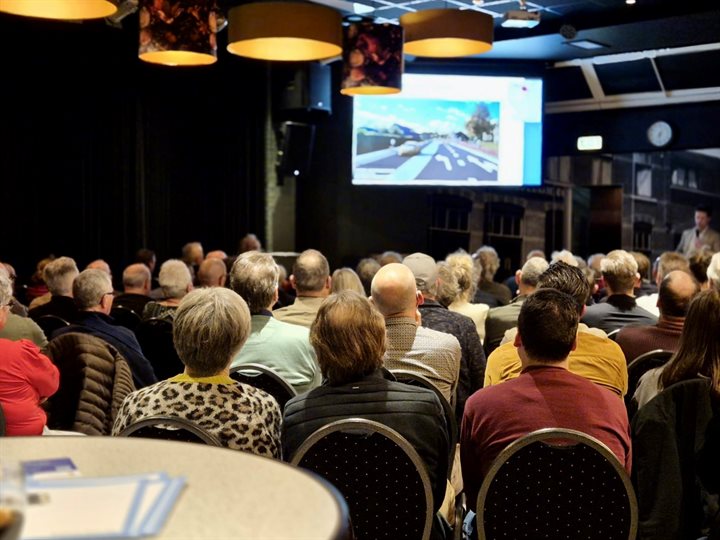 Volle zaal bezoekers kijkt naar de presentatie tijdens de inloopbijeenkomst