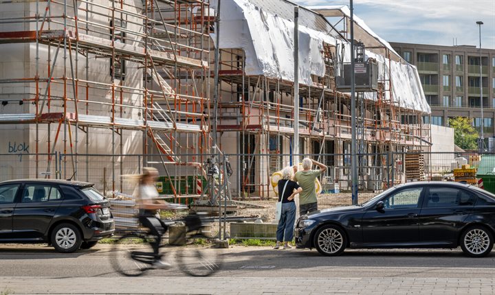 Nieuwbouwproject in Maastricht, op de voorgrond een fietser en wandelaars