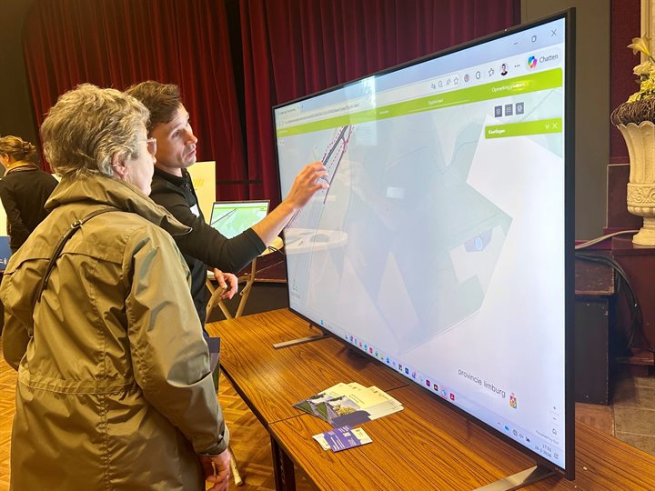 Een bezoeker krijgt uitleg bij het ontwerp van de N276