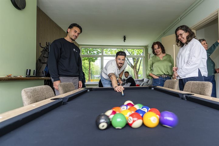 Jongeren spelen op een pooltafel
