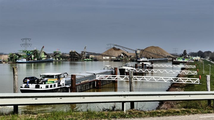 Een schip vaart de haven in bij de Grensmaas
