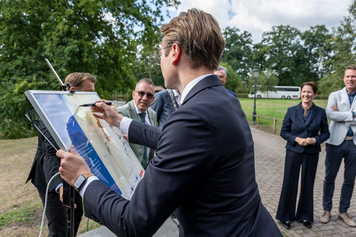 Minister Van Essen zet zijn handtekening