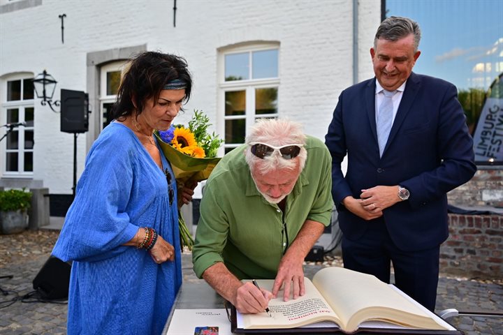 Jan Klompen zet zijn handtekening, zijn vrouw en gouverneur Roemer kijken toe