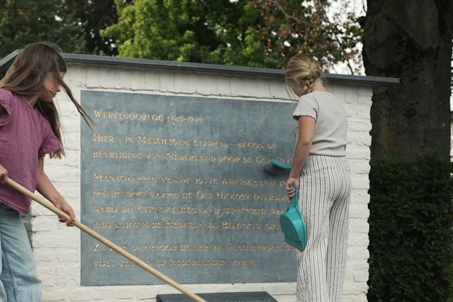 Kinderen maken het monument schoon in Mesch