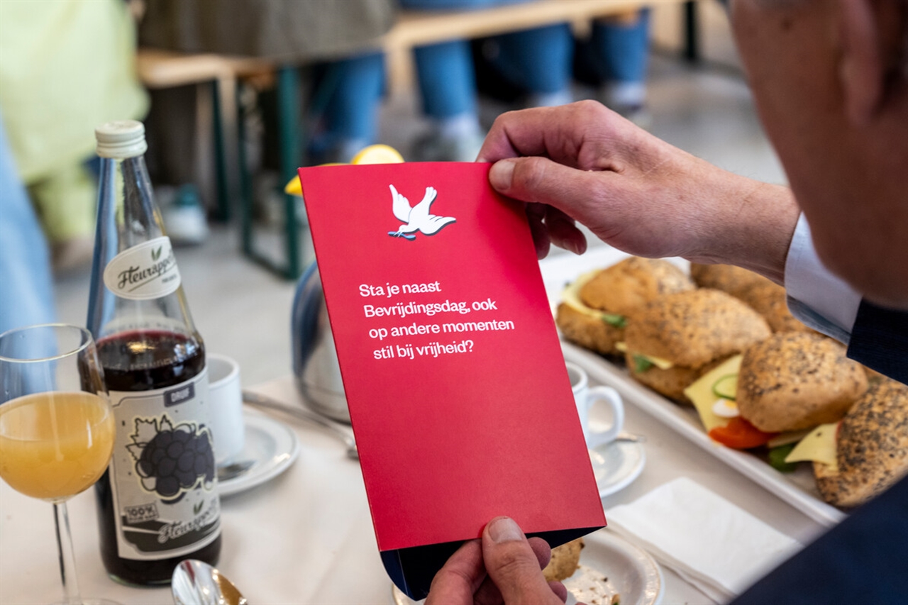 Bezoeker van vrijheidsmaaltijd met folder